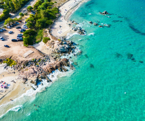 Spiaggia con rocce scolpite dal vento e mare cristallino in una baia tranquilla.